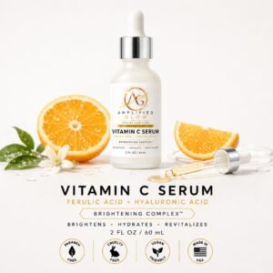 Amplified Glow Vitamin C Serum with orange slices, serum dropper, and citrus-inspired brightening ingredients on a clean white background.